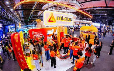 foto de um estande da mLabs com pessoas do time da mLabs e participantes do evento