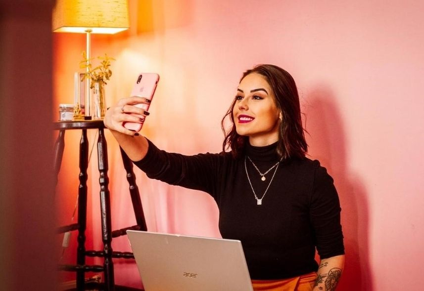 Embaixador da Marca: Imagem de uma mulher segurando o celular para fazer uma selfie