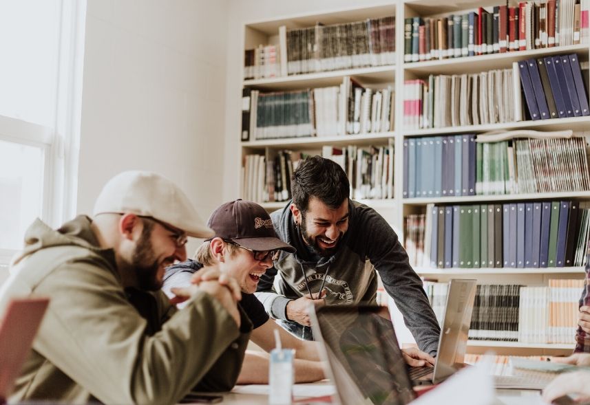 Escola e redes sociais: imagem de três adolescentes dentro de uma sala com uma prateleira cheia de livros