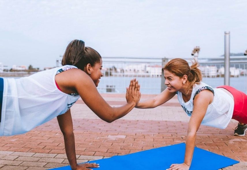 Marketing para personal trainer: imagem de duas mulheres se exercitandoapoiadas no colchonete