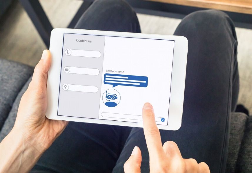O que é chatbot: imagem de duas mãos segurando um tablet realizando um antedimento via chatbot na tela