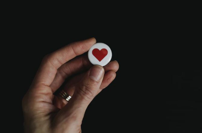 Prova Social: imagem de uma mão segurando um botão de coração