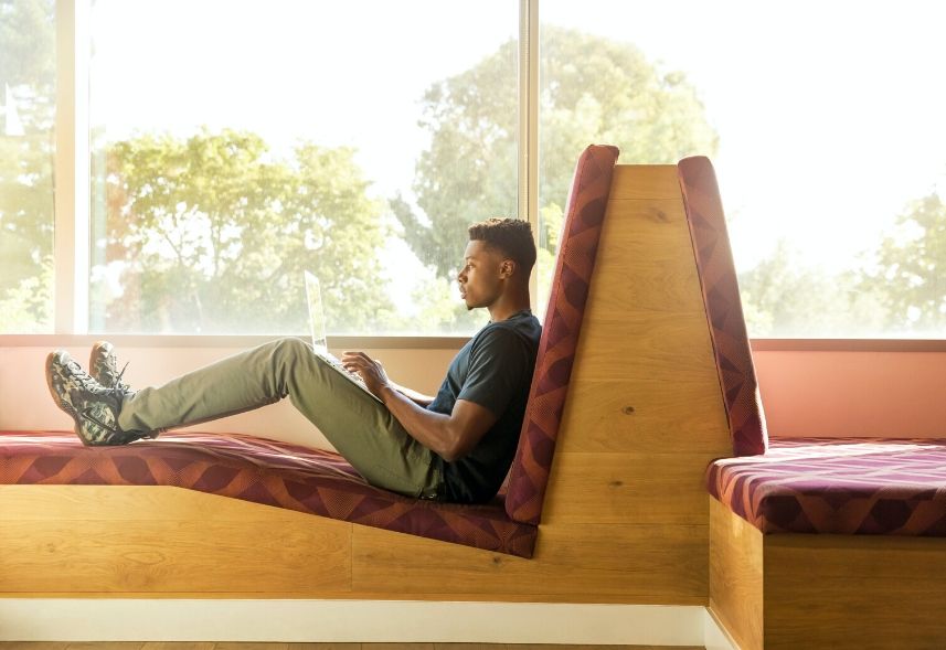 Recomendações no LinkedIn: imagem de um homem sentado num sofá com um notebook no colo digitando